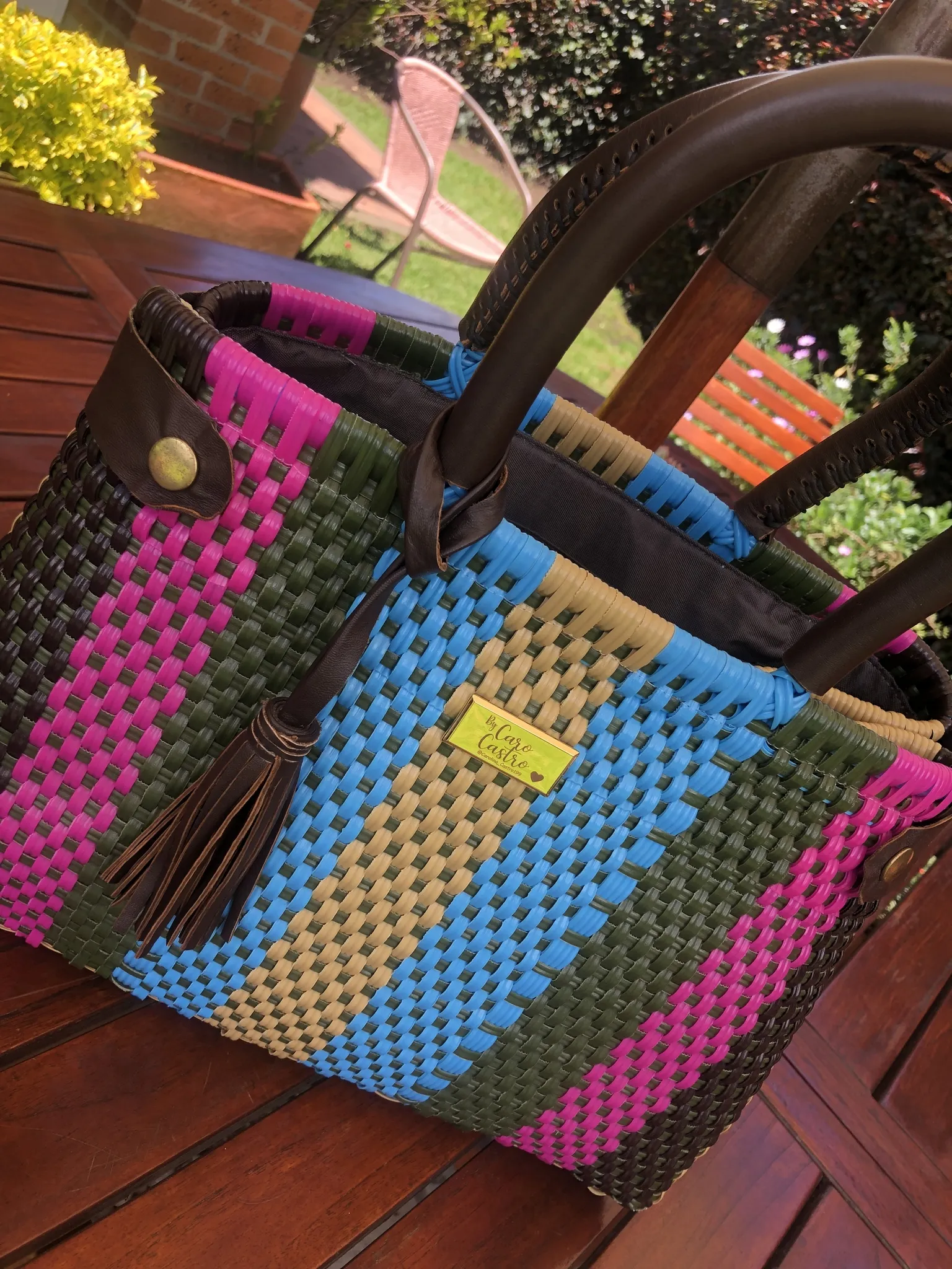 Cartera fucsia, azul y ocre, tejida a mano.