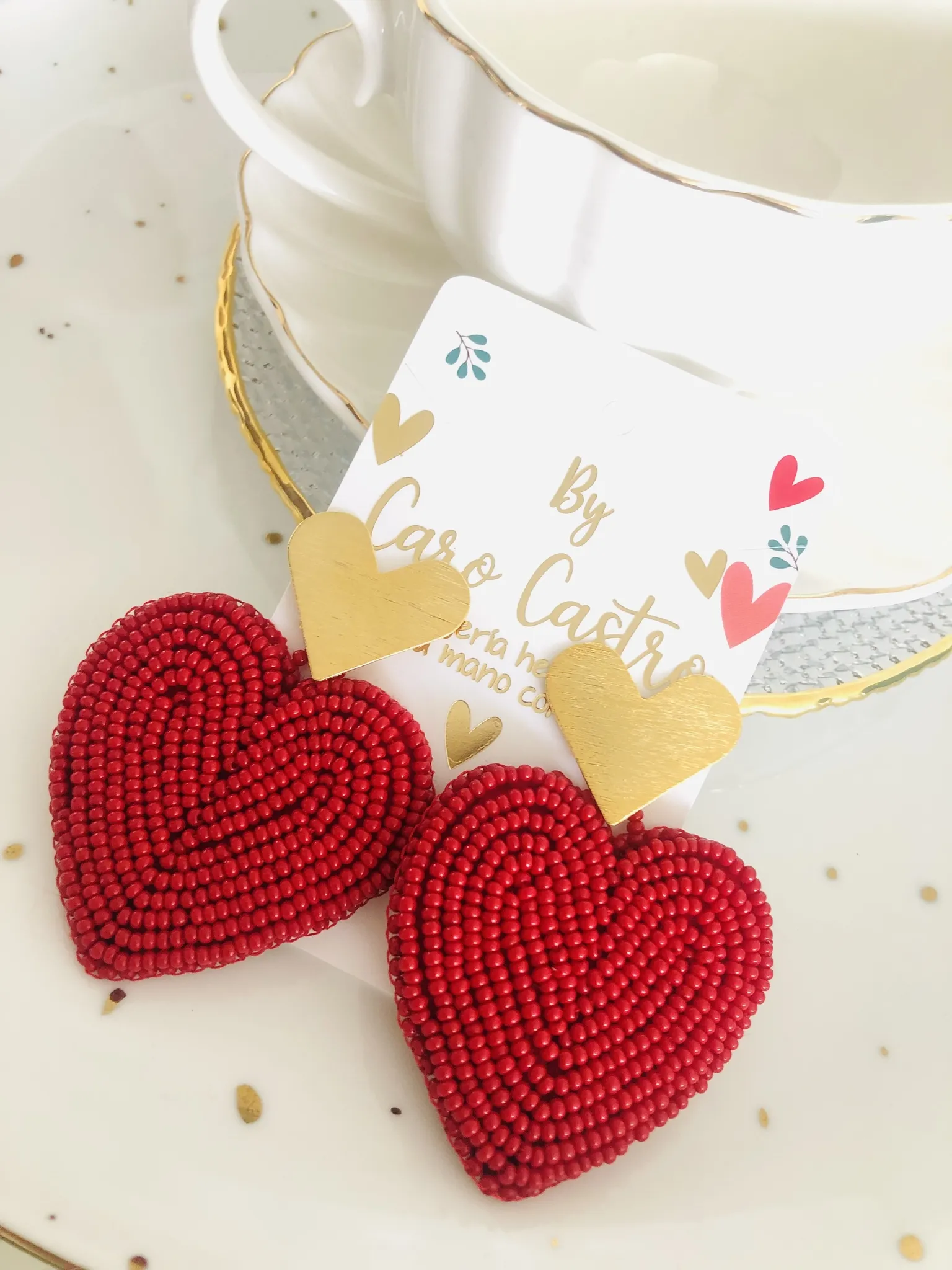  Aretes corazon rojo con topo dorado.