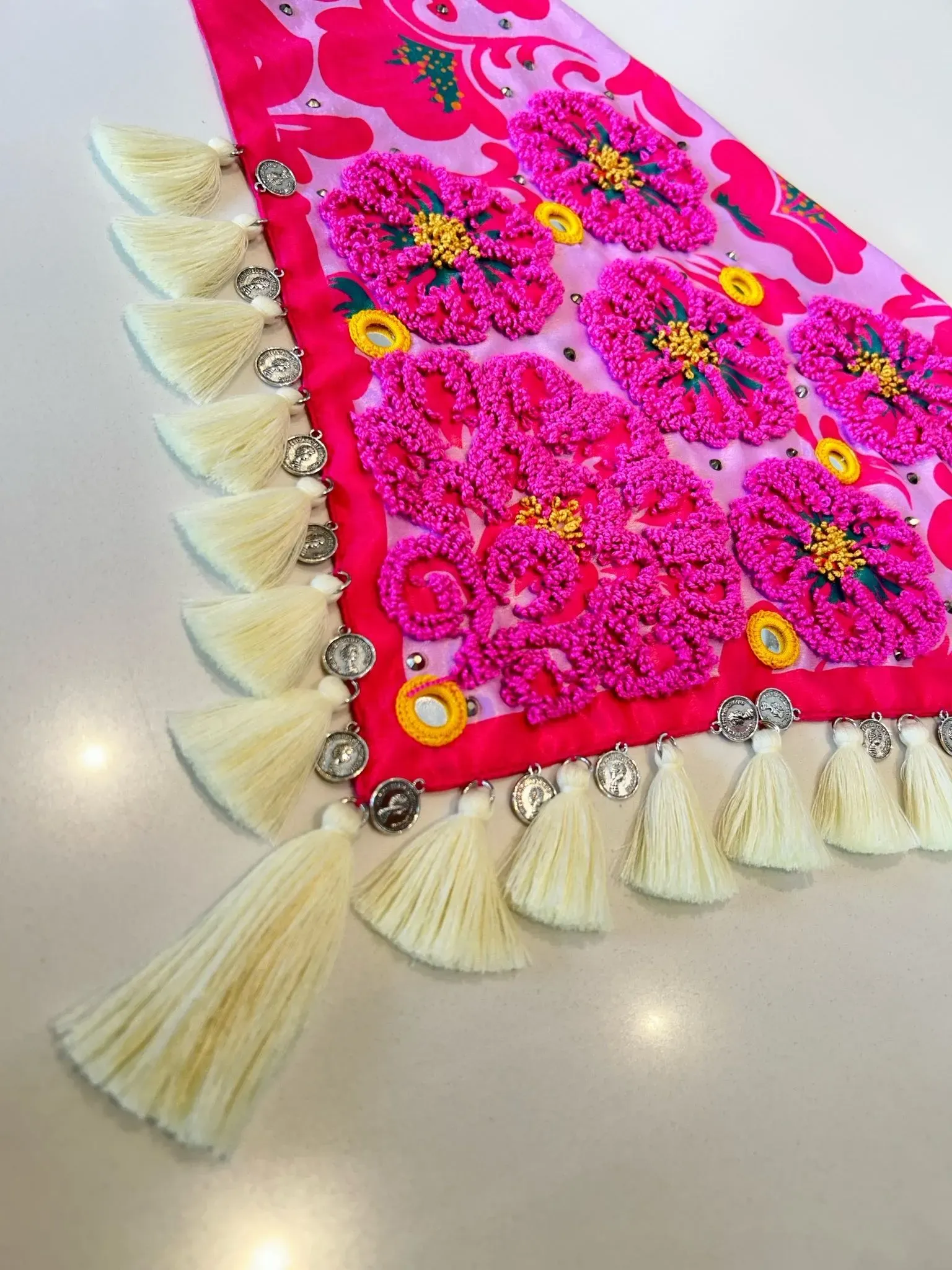 Pañoleta bordada con Flores Fucsia y borlas amarillas.